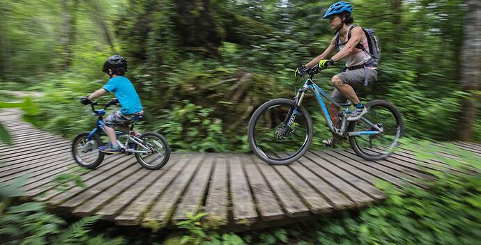 Becca Cahall follows her son Teplin, 5, as he hits the boardwalk on a trail at Duthie Hill Mountain Bike Park in Issaquah. (Steve Ringman/The Seattle Times)